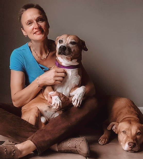 Iris Grimm with a dog in her lap and a dog by her side